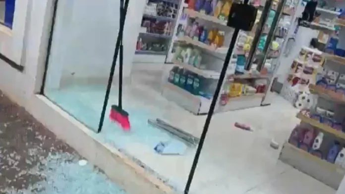 Los delincuentes rompieron la puerta de blindex para ingresar en una farmacia de Ciudad del Este.Foto: Captura Telefuturo.