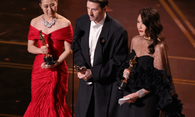 Maggie Kang, Chris Appelhans y Michelle L.M. Wong subieron para recibir el premio de Mejor Animación otorgado a la película Las Guerreras K-Pop.Foto: AFP.