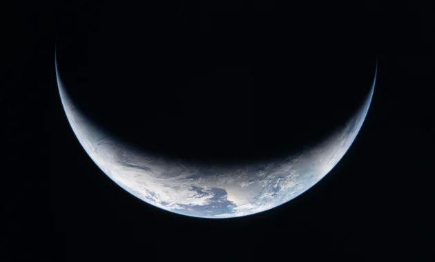Esta imagen de archivo tomada por un miembro de la tripulación de Artemis II y facilitada por la NASA muestra una franja de la Tierra iluminada contra la oscuridad del espacio a través de la ventanilla de la nave espacial Orión el 3 de abril de 2026.Foto: NASA / AFP.
