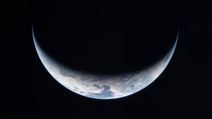 Esta imagen de archivo tomada por un miembro de la tripulación de Artemis II y facilitada por la NASA muestra una franja de la Tierra iluminada contra la oscuridad del espacio a través de la ventanilla de la nave espacial Orión el 3 de abril de 2026.Foto: NASA / AFP.
