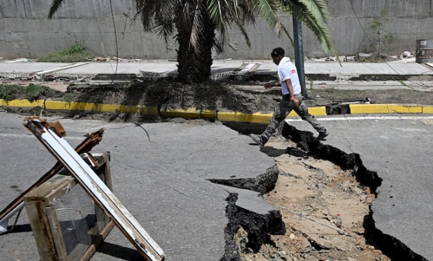 Un hombre camina por una calle agrietada tras un doble terremoto en Los Corales, estado de La Guaira, a unos 38 km al noroeste de Caracas, el 25 de junio de 2026.