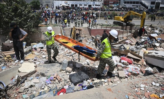 Miembros de la Policía Nacional Bolivariana transportan una camilla sobre los escombros de edificios dañados en Catia La Mar, La Guaira, Venezuela, el 26 de junio de 2026, tras unos terremotos mortales. Foto: AFP