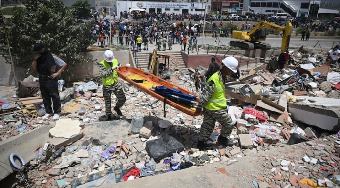 Miembros de la Policía Nacional Bolivariana transportan una camilla sobre los escombros de edificios dañados en Catia La Mar, La Guaira, Venezuela, el 26 de junio de 2026, tras unos terremotos mortales. Foto: AFP