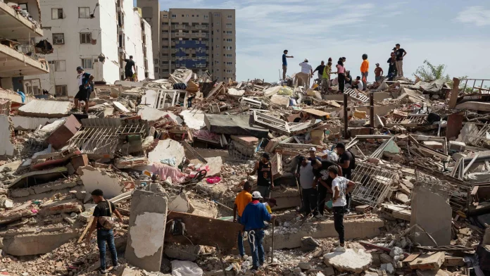 Personas caminan entre escombros de edificios afectado por terremotos este jueves, en Catia La Mar (Venezuela). Foto: Ronald Peña R./EFE. Personas caminan entre escombros de edificios afectado por terremotos este jueves, en Catia La Mar (Venezuela). Foto: Ronald Peña R./EFE.