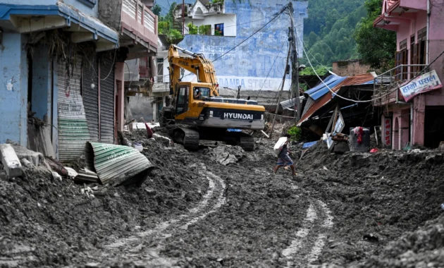 Un hombre camina entre lodo tras las inundaciones repentinas en Devighat, en el distrito de Nuwakot, Nepal, el 31 de agosto de 2026.ARUN SANKAR/AFP