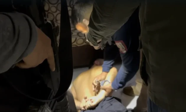 Agentes policiales ponen las esposas a uno de los detenidos tras el operativo Gota a gota llevado a cabo en Asunción y Luque.Foto cedida por el Ministerio Público/Captura de video.